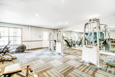 Fitness center with exercise equipment and mirror accent wall